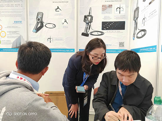 亞泰光電展臺前，公司內窺鏡工程師與客戶親密交談為